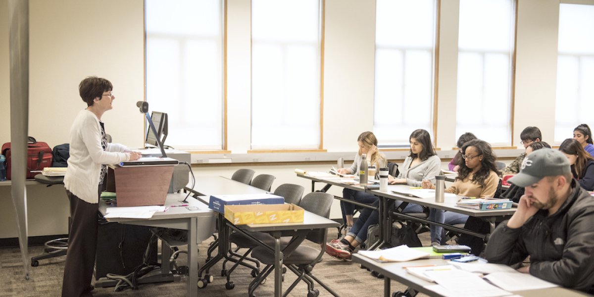 A professor standing at a podium in front of a class of accounting students