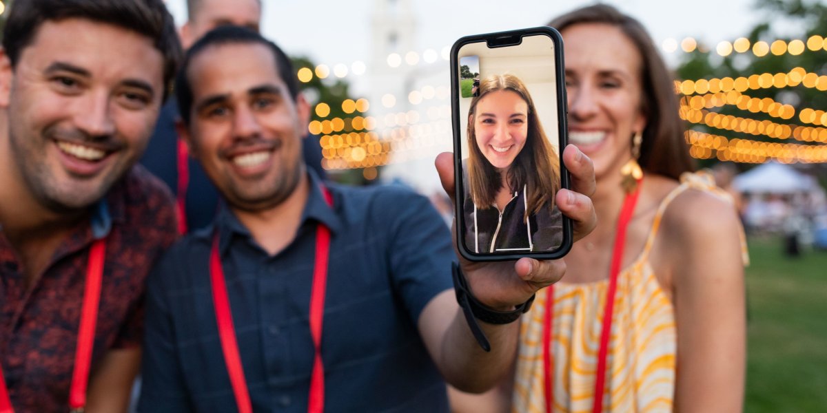 A woman appears on a Facetime call on Chapel Lawn during Reunion
