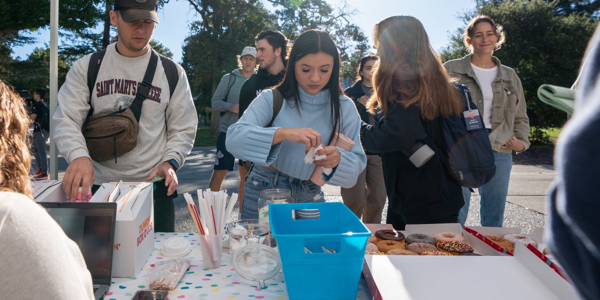student signing in for coffee and donuts at wake up wednesday