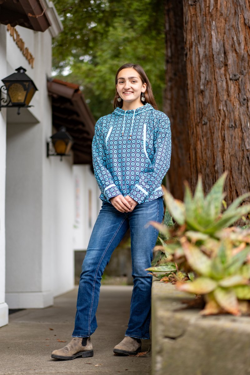 Amaya Simoni-Walters '25 on campus with a redwood tree behind her