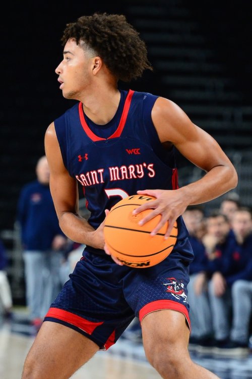 Men's Basketball player Jordan Ross holds the ball