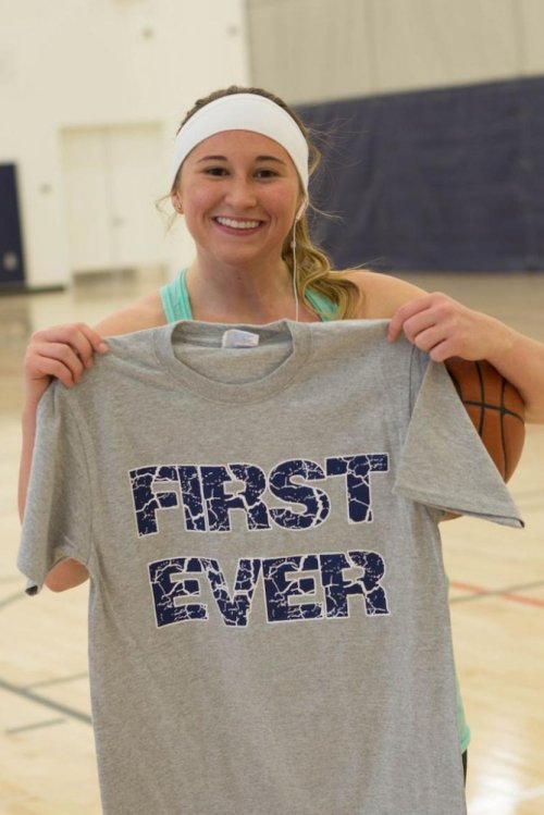 Student Michelle Conway holds up a T-shirt with FIRST EVER printed on it 