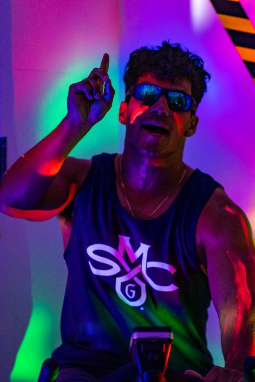 Student on cycle in day-glo colors for glow spin class