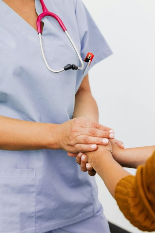 Nurse holding the hands of a patient