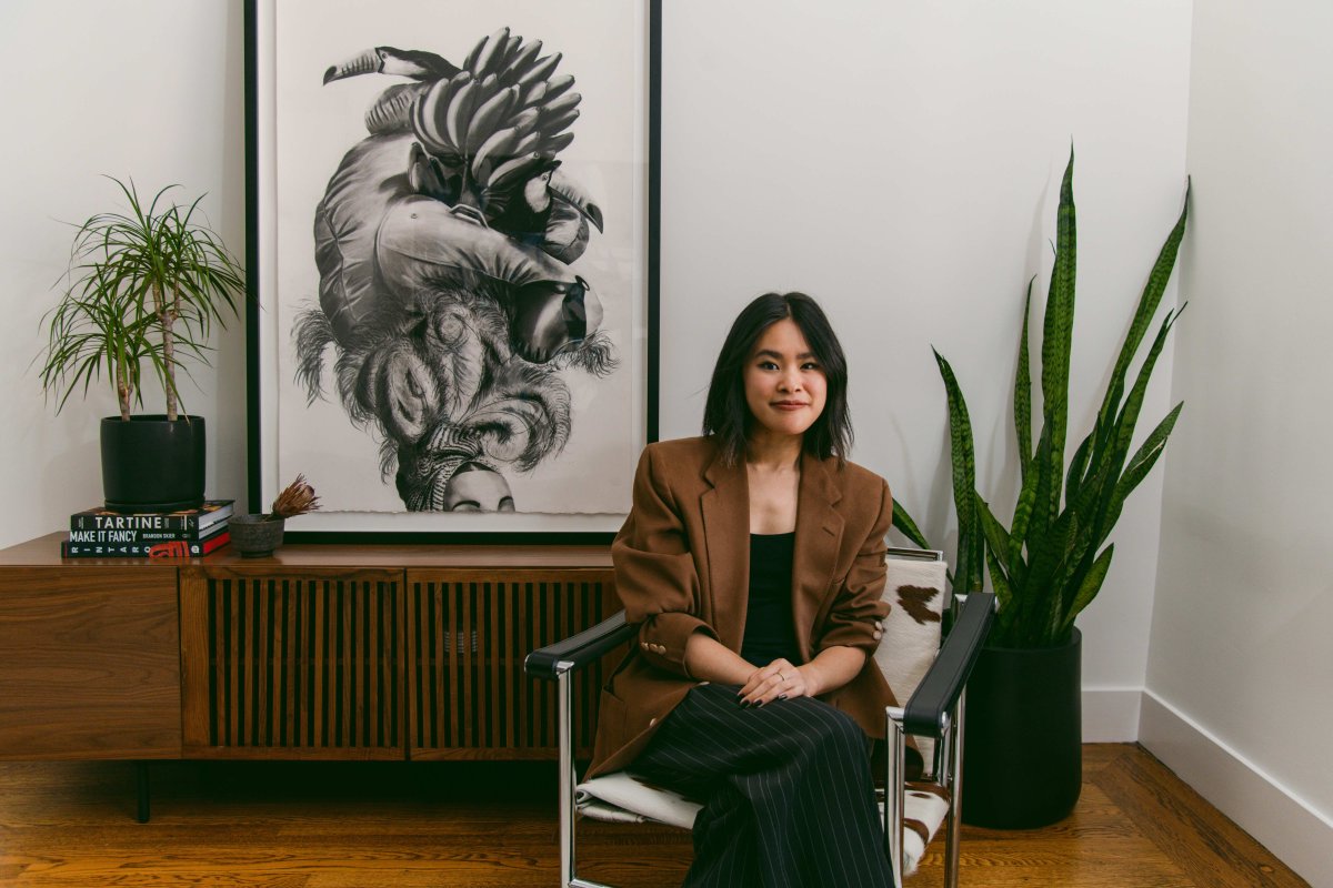 Sierra Nguyen sits in her living room, in front of a large print