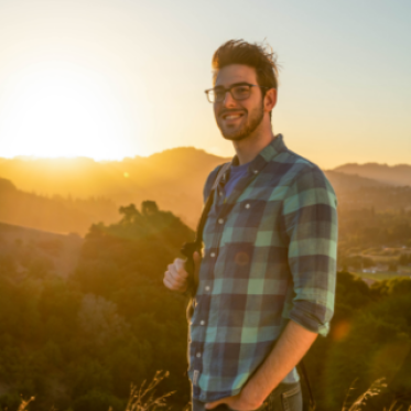 Student standing outside carrying notebook
