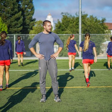 A student coaching soccer players
