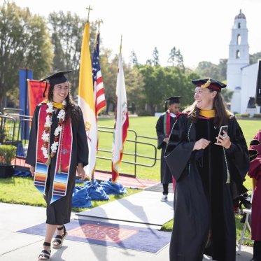 EES Student in graduation garb walking across the stage