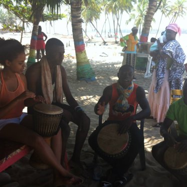 people sitting outside in a circle playing drums