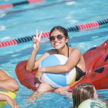 Students at the Pool lounging on pool floaties
