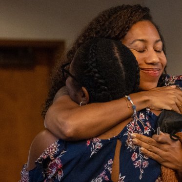 SMC faculty members hug