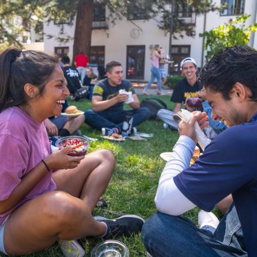 Students eatting lunch in a circle laughing