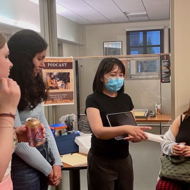 three women are listening to a lady where she is explaining