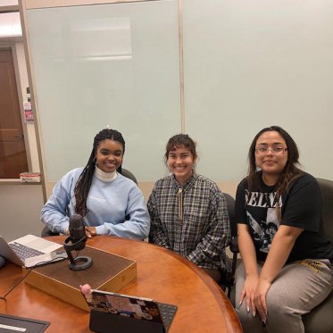 three women sitting and smiling