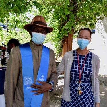 two people wearing mask standing and posing for picture