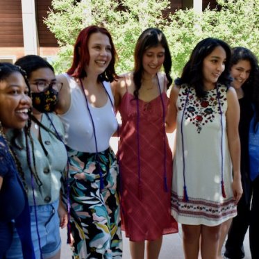 group of people smiling and standing closely 