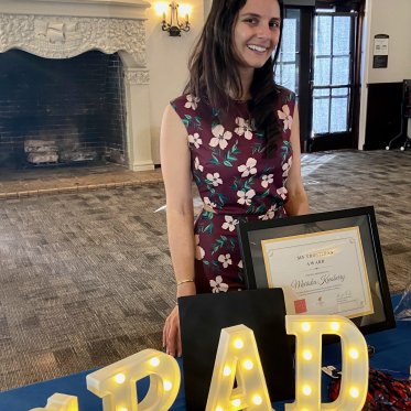 women smiling and standing behind a table