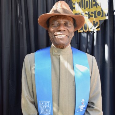 man wearing a stole and smiling