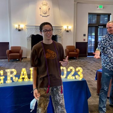 man smiling and standing Infront a table