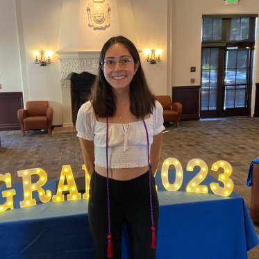 women smiling and standing infront of a table