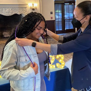 girl helping other girl to wear stole