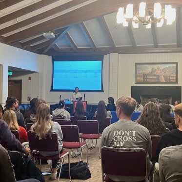 many people sitting and listening and a man is talking