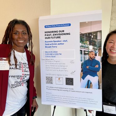 image of two women standing next to a poster
