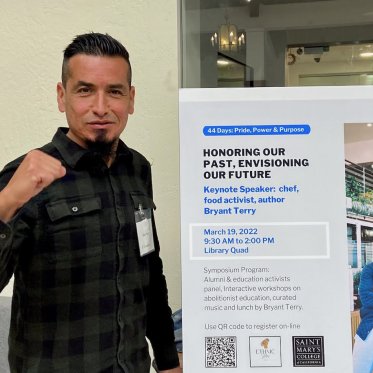 a man standing next to a poster