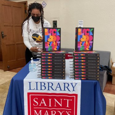 person standing next to a pile of books