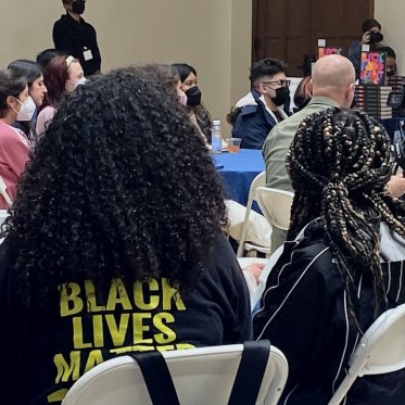 image of 2 people sitting, only the back side of there heads are visible