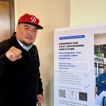 a man standing next to a poster