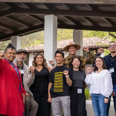 group of people standing and showing their fists