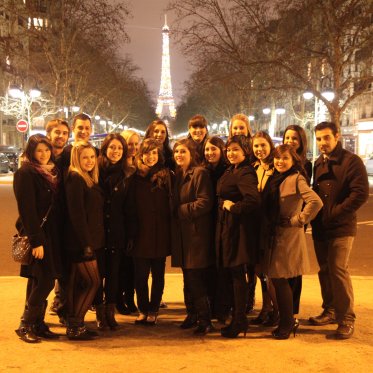 Group in front of the Eiffel Tower at night