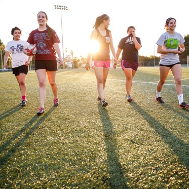 Students on a field with a ruby ball