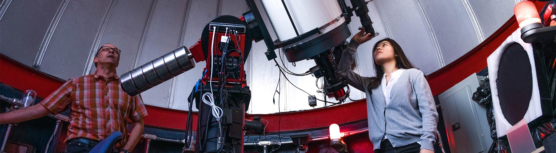 student looks through telescope