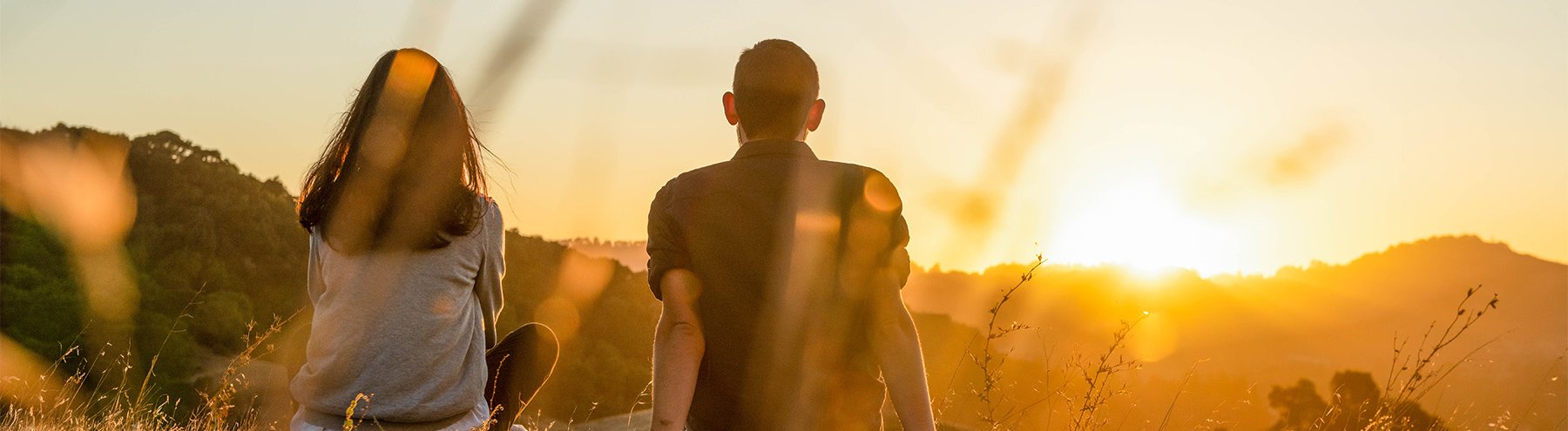 Students sit atop mountain overlooking the sunset