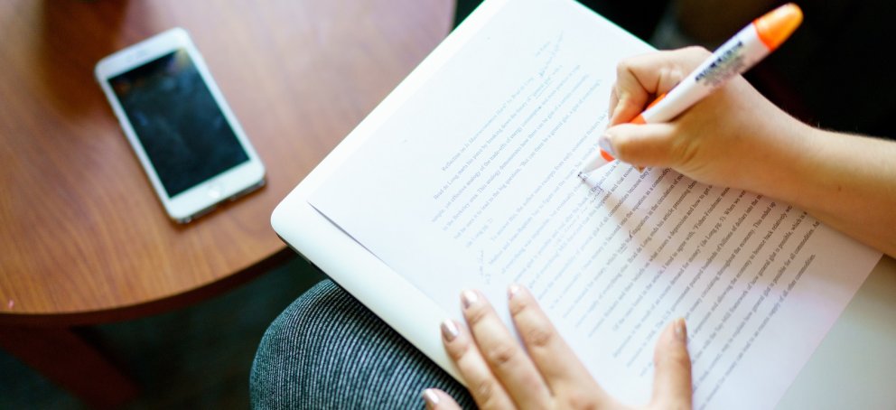 A writer marking up a printed paper
