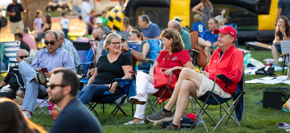 Four people sit and talk outside at Music on the Lawn