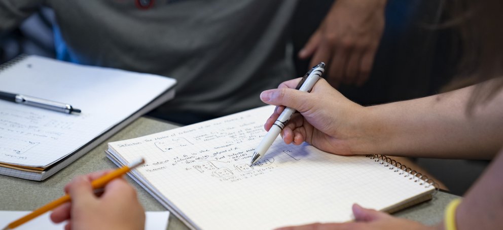 A closeup of students taking notes