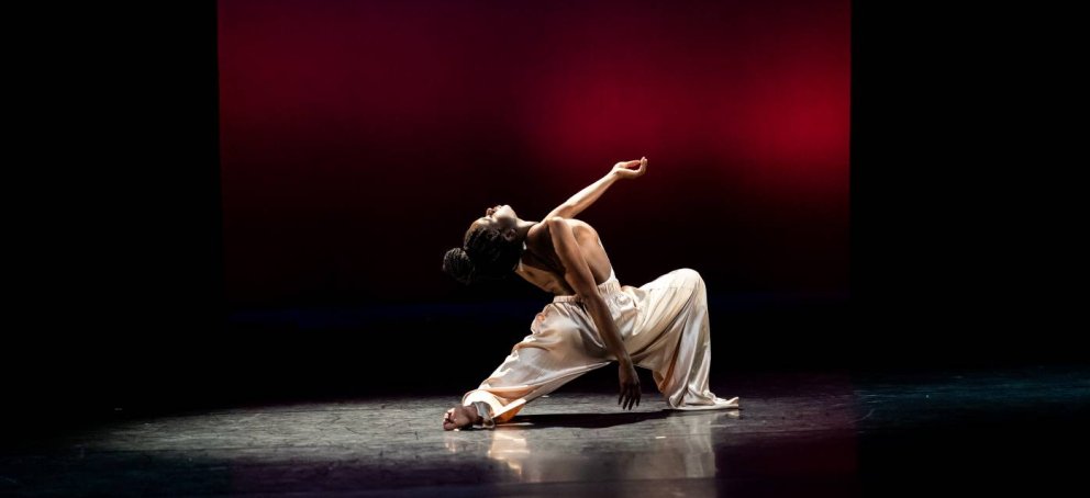 Dancer in white dress with a dark background