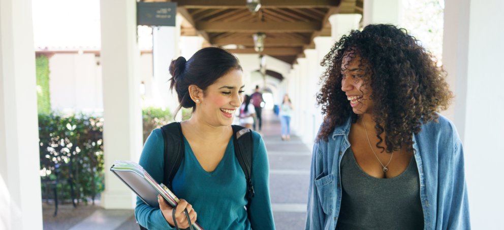 Two students walking with backpacks on
