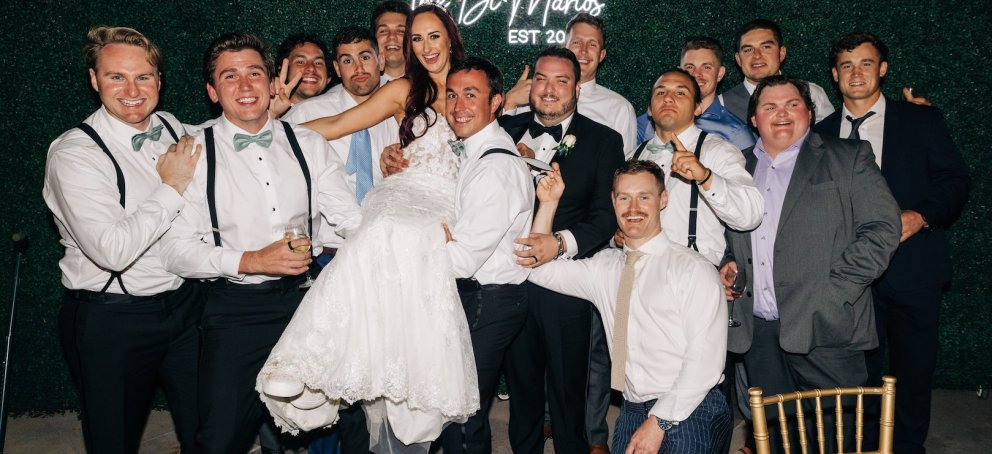 A dozen people lift the bride in her gown
