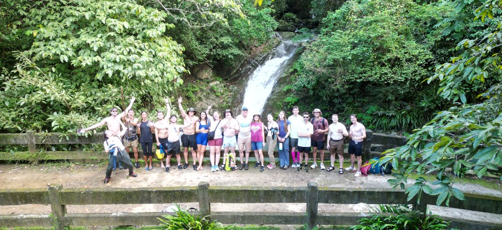 Students standing in front of a watefall