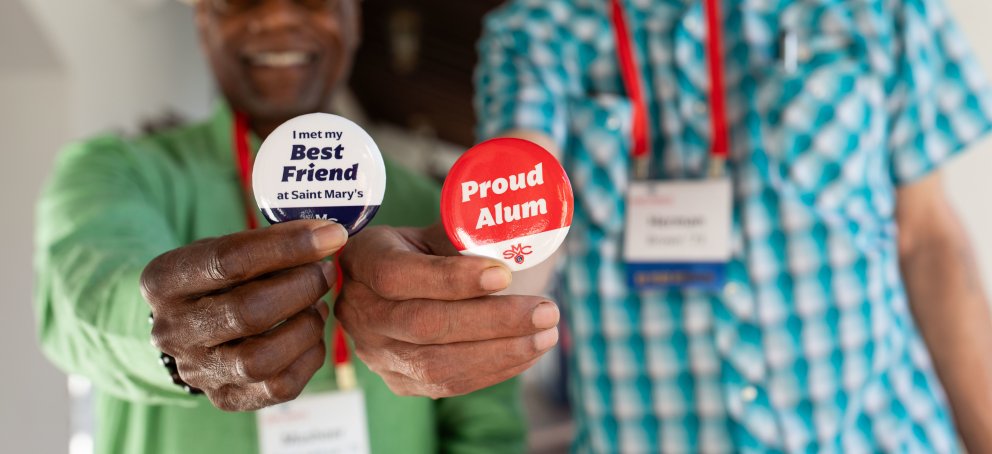 Close up of pin-on buttons that read: Best Friend and Proud Alum