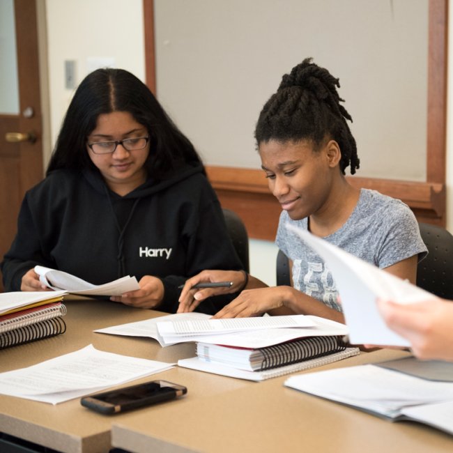 Students in class looking at their papers smiling