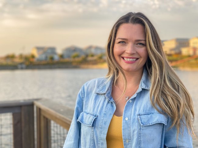 Mckenzie Langefeld looking at camera with her back to a waterfront