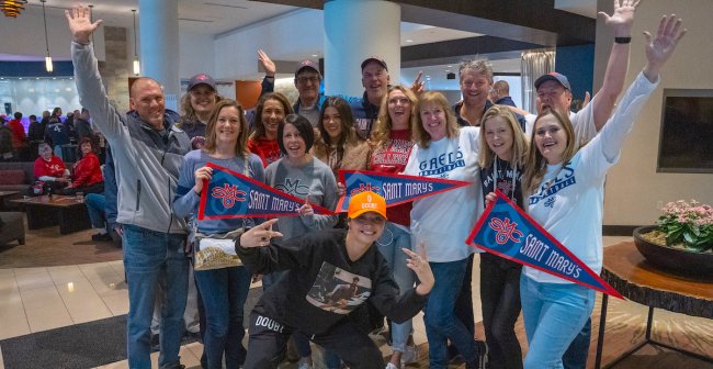 Fans smile and throw their hands in the air