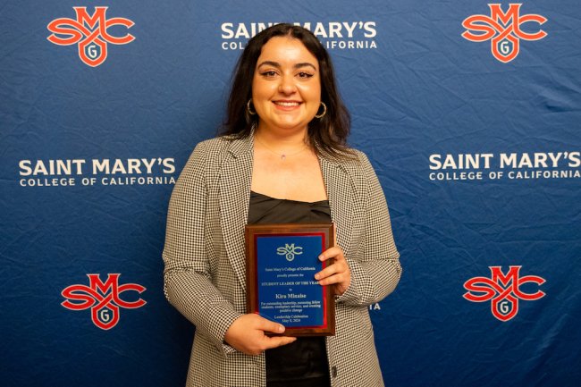 Student Kira Minaise holding up a plaque for 2024 Student Leadership Awards