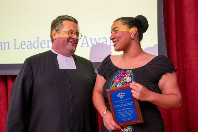 Brother David Caretti, FSC, and Rebecca Carranza '26 holding up a plaque for 2024 Student Leadership Awards