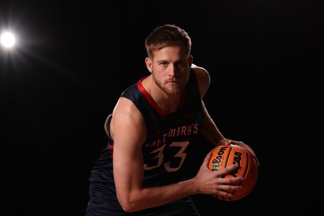 Men's Basketball player Luke Barrett holds the ball